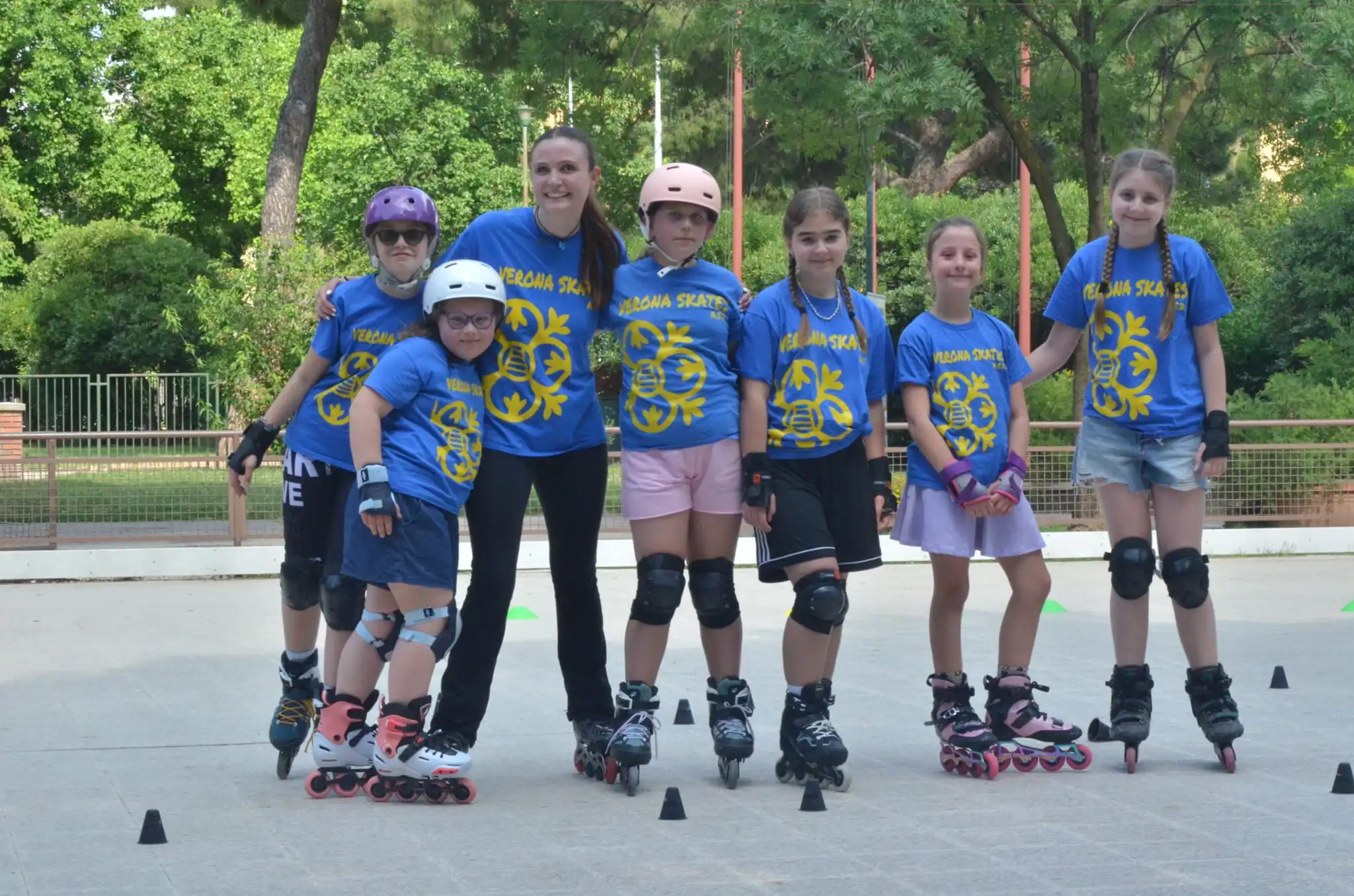 Allenatori e atleti del Verona Skates A.S.D. con i pattini addosso che sono in pista per una dimostrazione artistica.